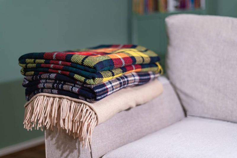 Checked blankets stacked on a couch.