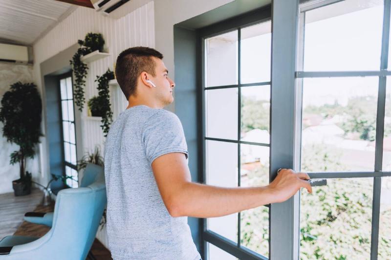 Man opening apartment window. 