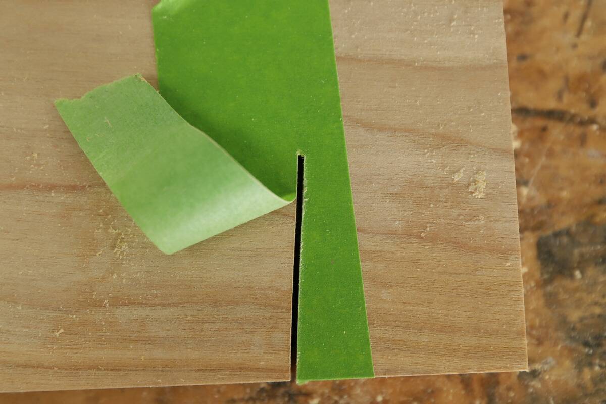 A cut made in wood through painter's tape.