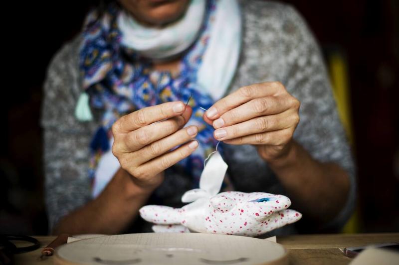 Woman hand sewing a doll.