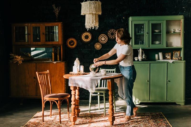 молодая-женщина-с-рыжими-волосами-остается-на-кухне-2024-10-13-21-28-33-utc Молодая женщина заваривает чай на кухне в винтажном стиле.