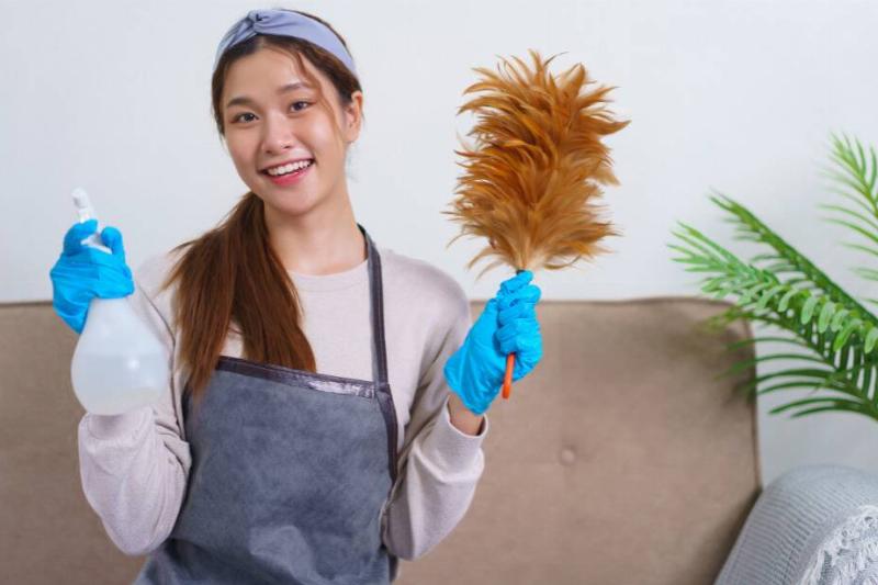 Woman holding a feather duster.