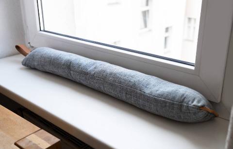 A draft excluder by a window. 