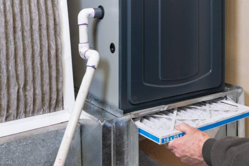 Person changing furnace filter. 