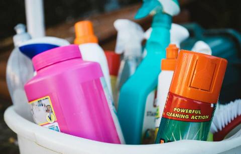 Cleaning supplies in basket that are each labeled. 