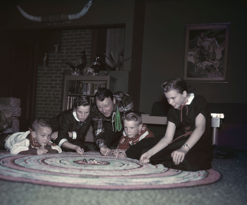 Roy Rogers With His Kids playing with toys on area rug