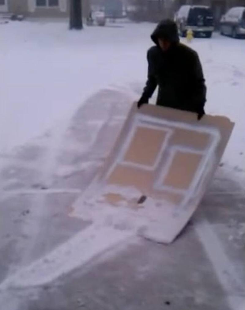 Скриншот 17.12.2025 в 14.17.37 Человек толкает снег куском фанеры.