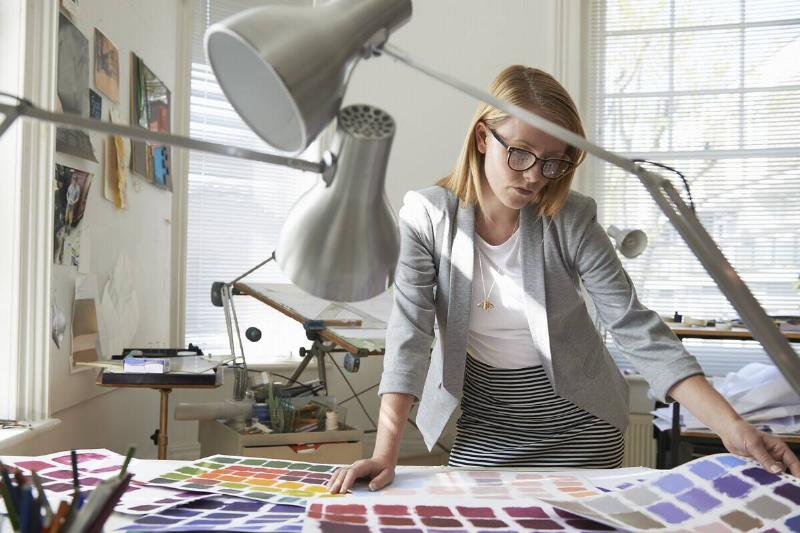 художник-скрупулезно-подбор цветов-в-солнечной-улице-2025-04-05-03-13-48-utc Дизайнер интерьера рассматривает образцы цветов.