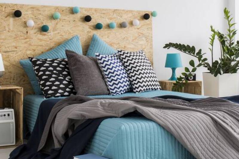 A bed with a ton of throw pillows and blankets. 