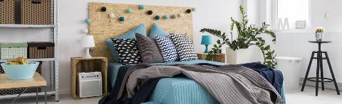 A bed with a ton of throw pillows and blankets. 