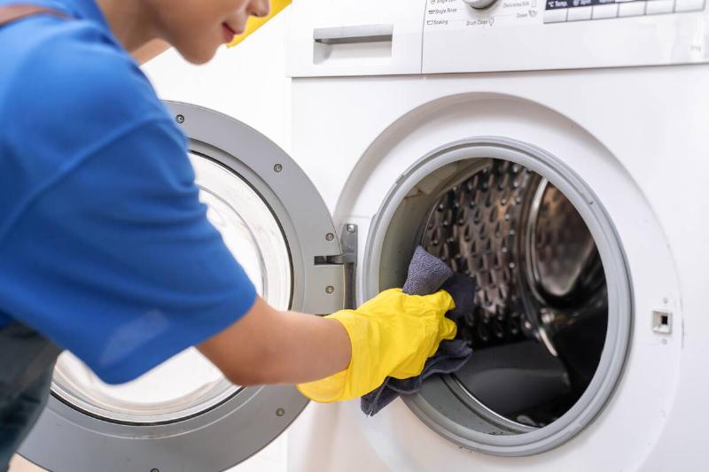 Woman washing inside of washing machine. 