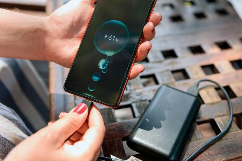Woman plugging in phone to charge. 