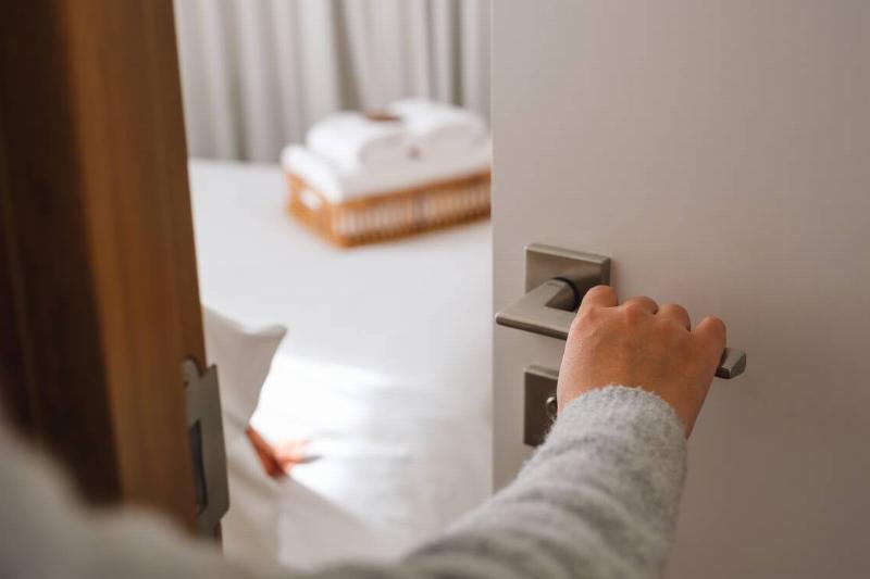 Hand closing a bedroom door.