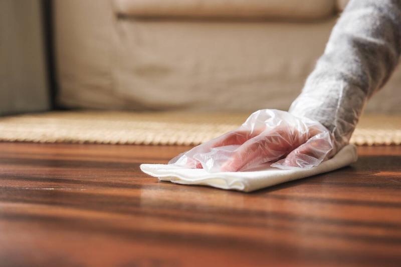Woman wiping floor with damp paper towel. 