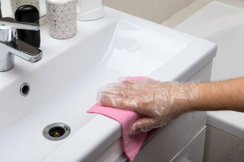 Hand wiping up mess on sink. 
