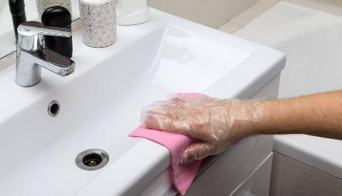 Hand wiping up mess on sink. 