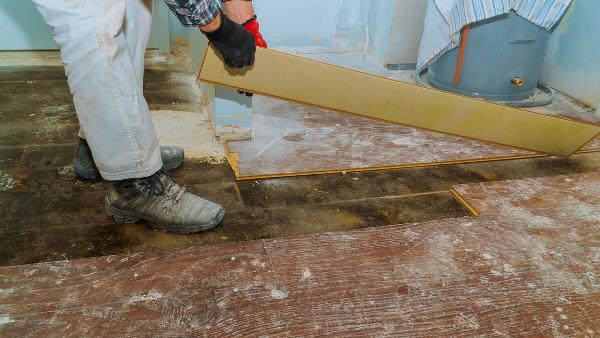A man removing old flooring in a house. 