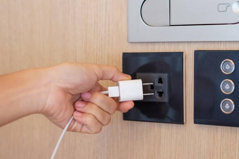 Person unplugging charger from wall