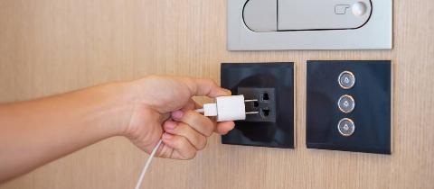 Person unplugging charger from wall