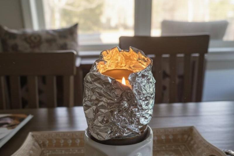 починить горящую свечу Свеча, завернутая в алюминиевую фольгу, чтобы она горела более равномерно.