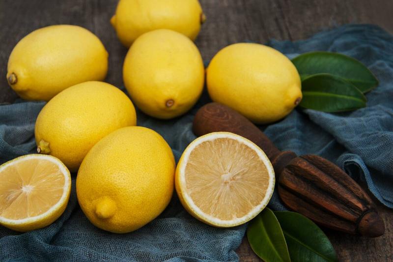 Fresh ripe lemons on a old wooden table.