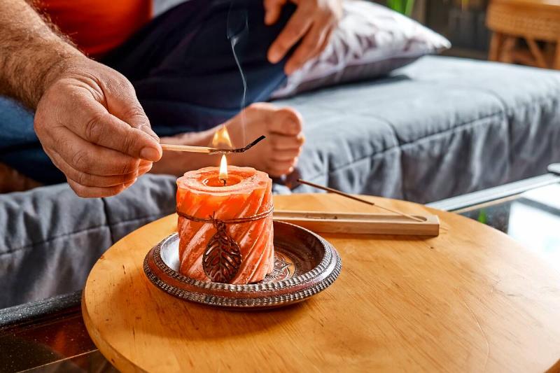 Hand of man lighting a candle.