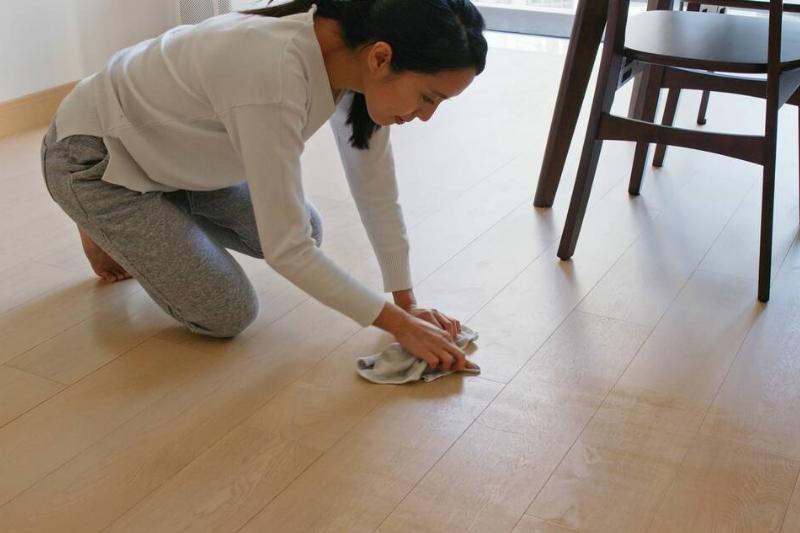 Woman cleaning scuff off of the floor.