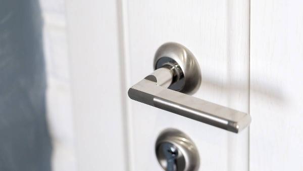 A lever-style door handle on a door. 