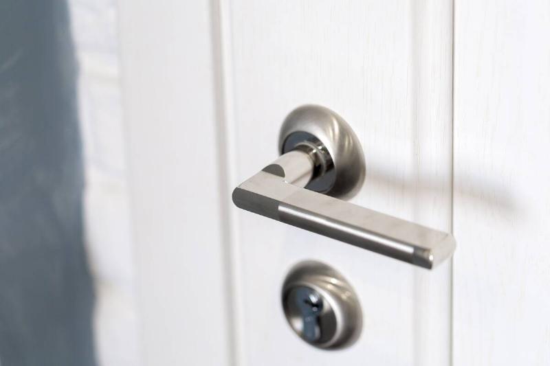 A lever-style door handle on a door. 
