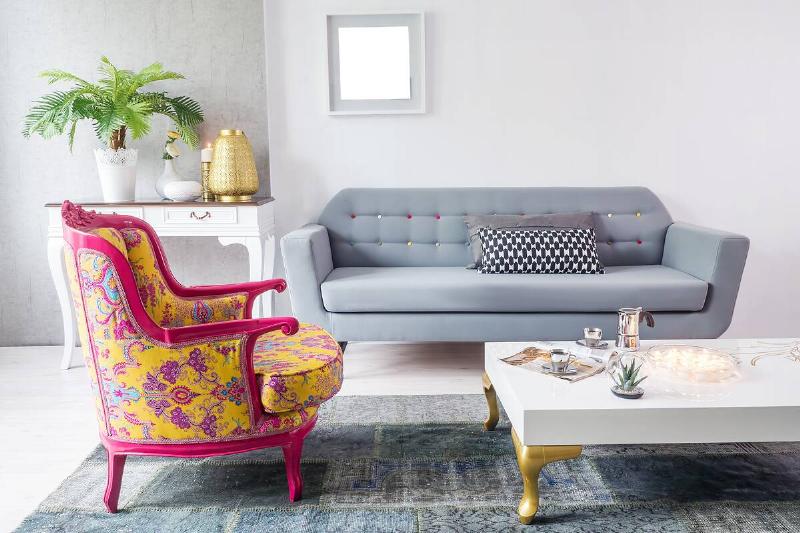 A modern couch with an antique chair.