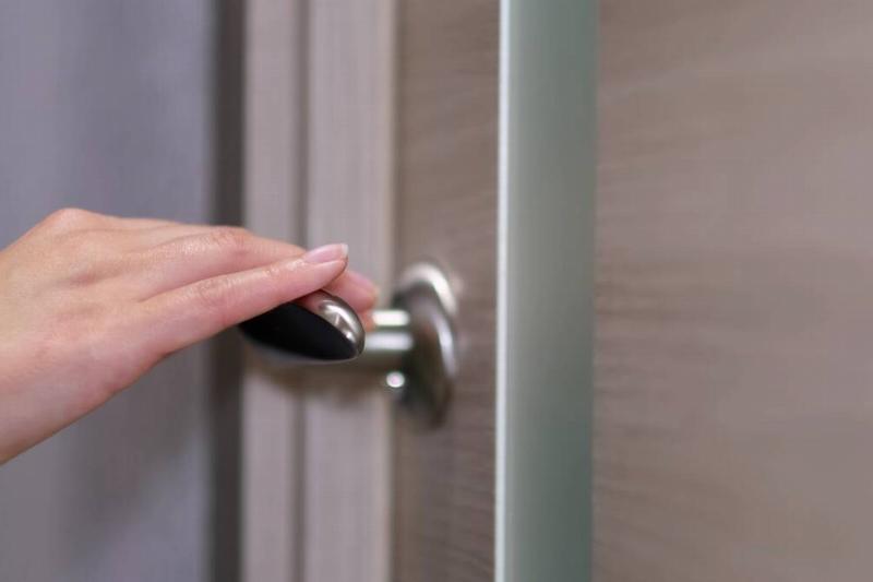 женщина-вид сбоку-входит-в-светлую-комнату-берет-2025-02-22-16-53-33-utc Ручное закрытие двери.