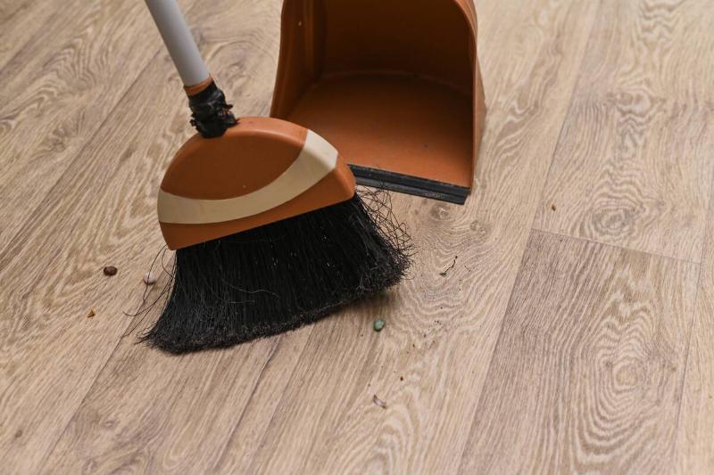 Sweeping dirt into a dustpan.