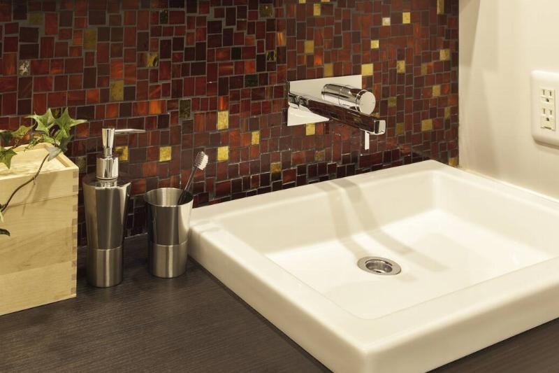 Small tiles around a bathroom sink. 