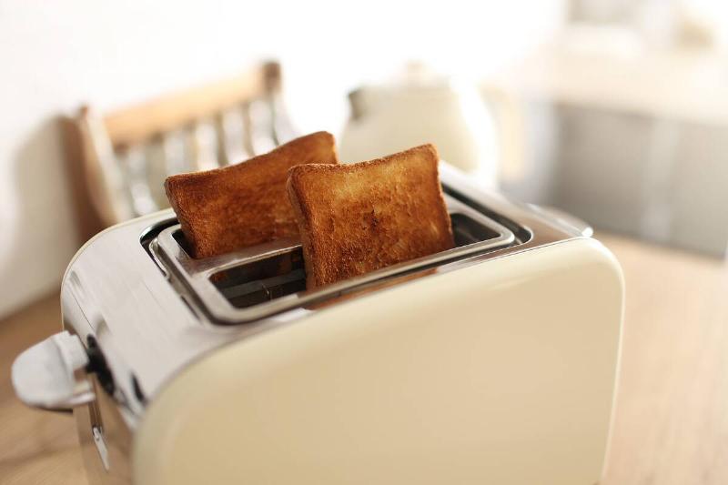 A toaster with two pieces of toast sticking out. 