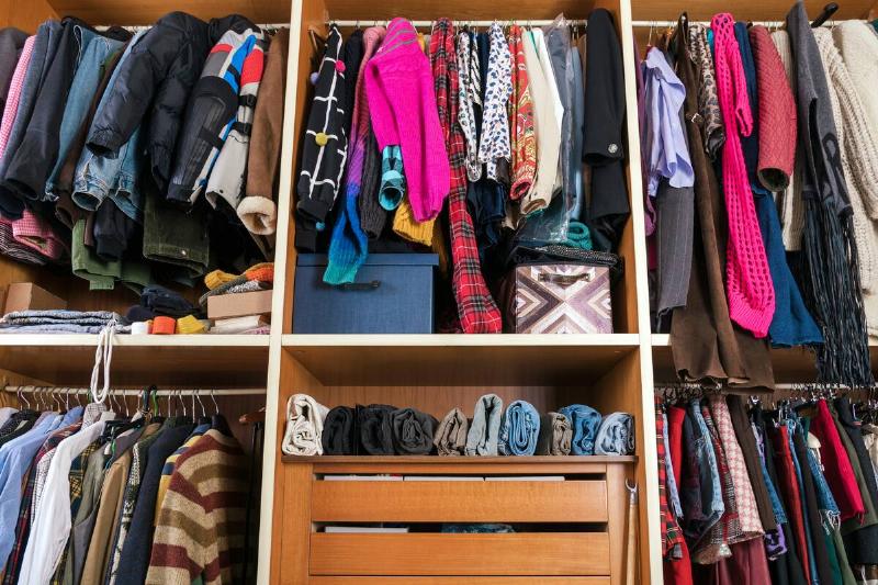 A closet bursting with clothes. 