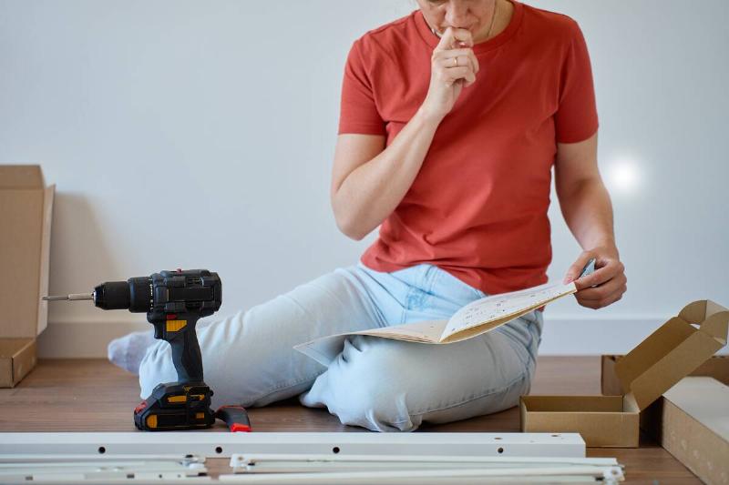 Person reading instructions for assembling furniture. 