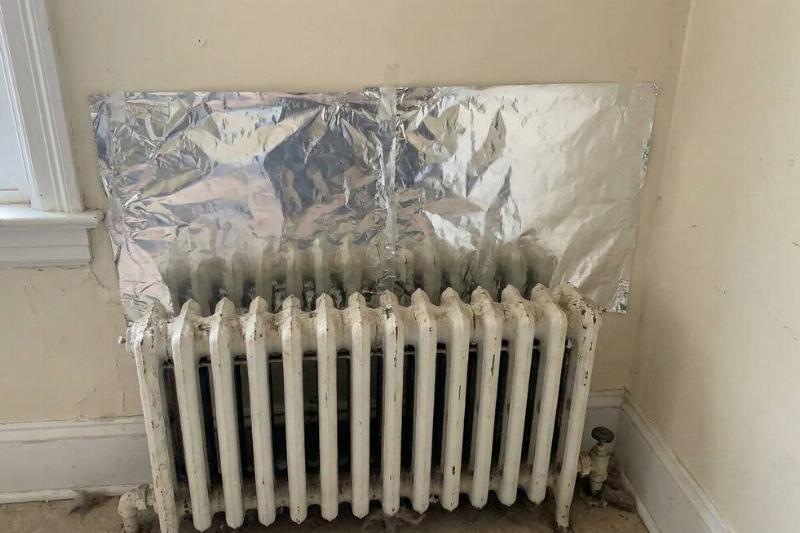 Aluminum foil attached to a wall behind a radiator.