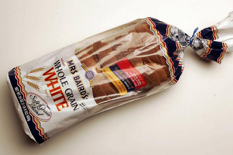 Loaf of Mrs. Baird's whole grain white bread placed on a white-topped table