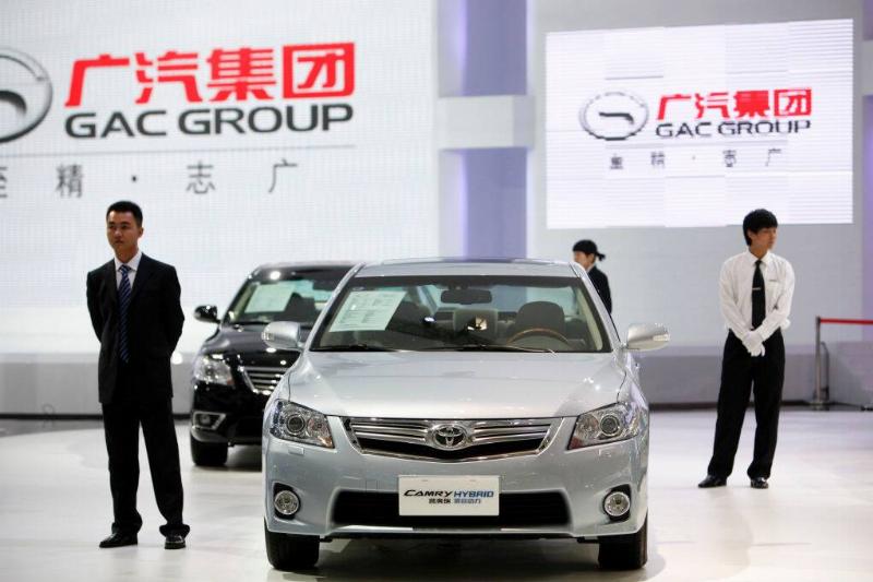 Two men standing near a silver 2011 Toyota Camry