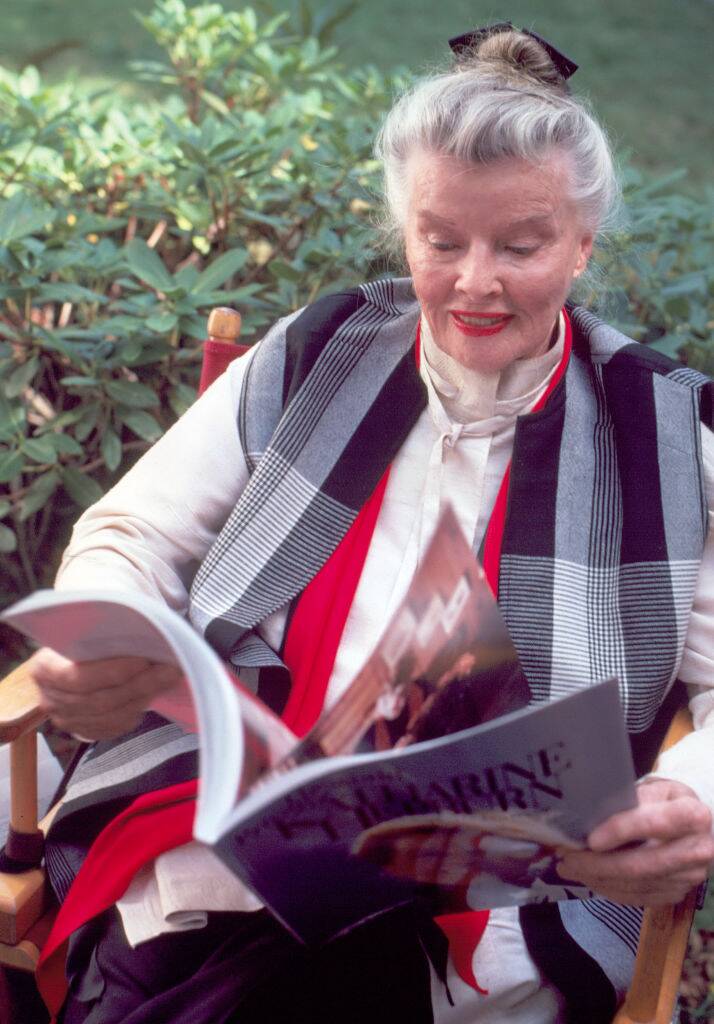 Katharine Hepburn reading a magazine outside