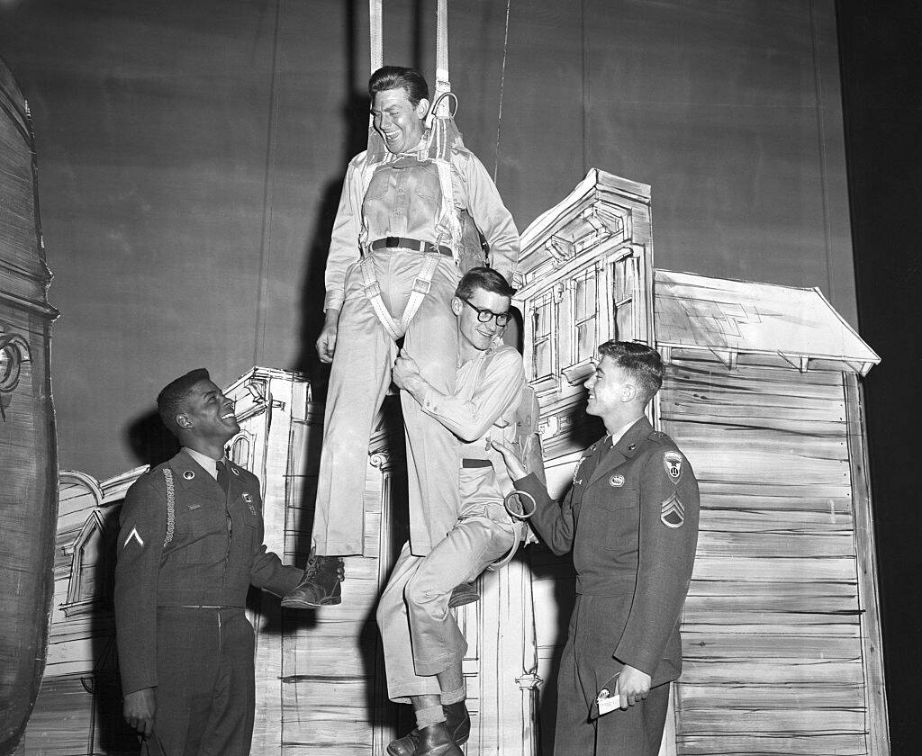 Andy Griffith hanging over three men on a theater stage