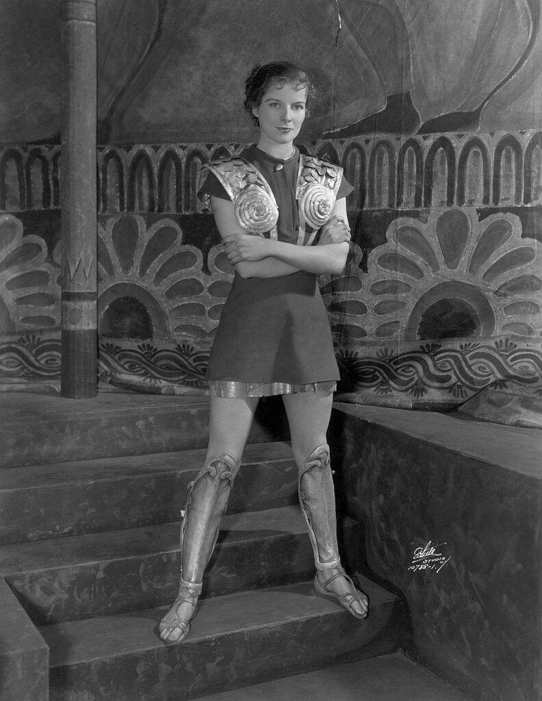 Katharine Hepburn standing in her costume for 'The Warrior's Husband'
