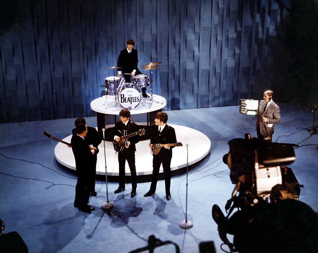 The Beatles, Ed Sullivan and a stagehand standing on stage at 'The Ed Sullivan Show'