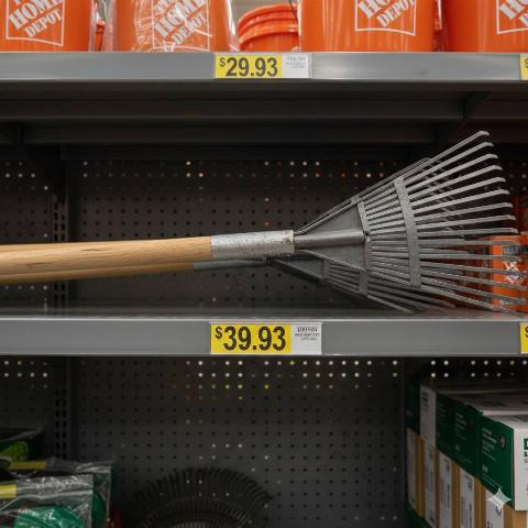 A rake on the store shelves of Home Depot with a price tag that ends in the number 3. 