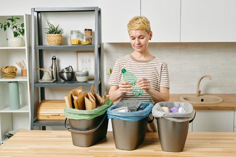 Woman sorting recycling at home. 