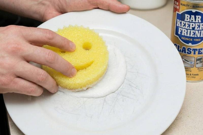 A scrub Daddy being used with Bar Keeper's Friend to wipe scratches off a plate. 