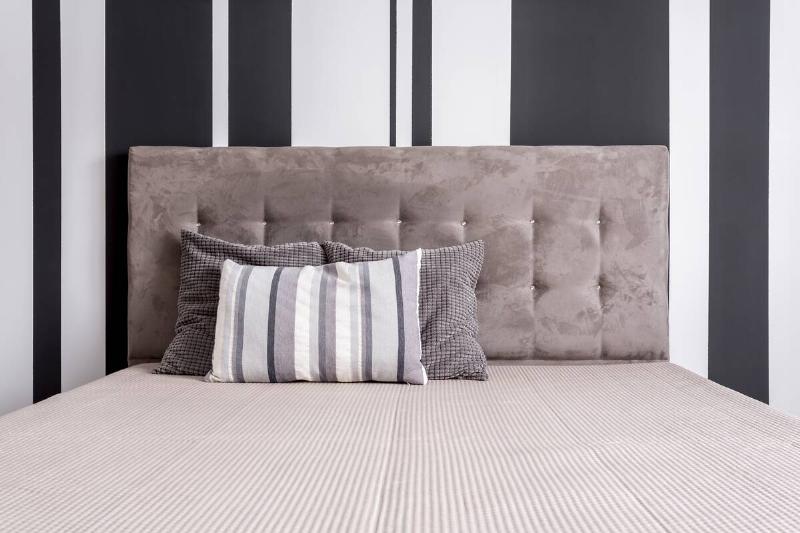 A bed with a striped fitted sheet. 