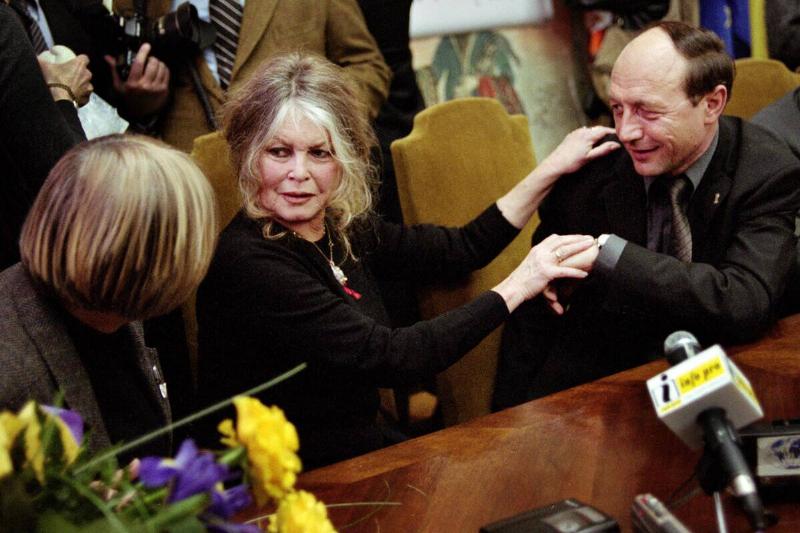 Brigitte Bardot sitting with Traian Basescu and a woman