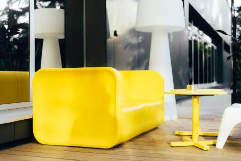 Yellow plastic couch in living room. 
