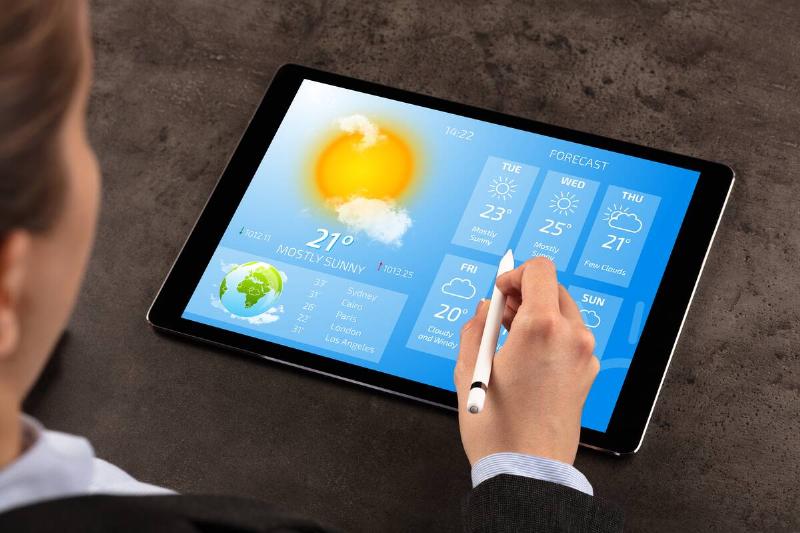 Woman checking weather forecast on tablet. 